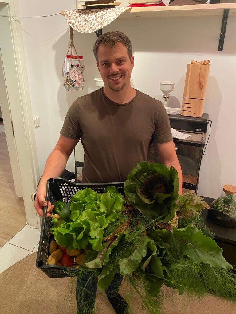 Gregor Karmann mit einer Kiste voll frischem Gemüse