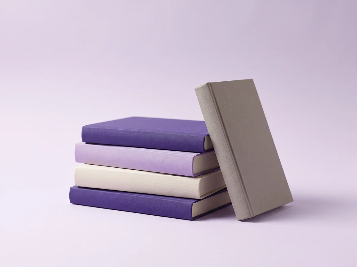 Stapel schlichter Bücher in den beyond100-Markenfarben