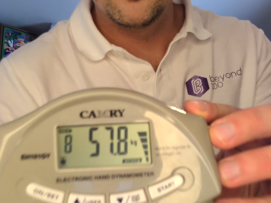 Gregor misst seine Griffkraft mit dem Handdynamometer, das Display zeigt 57,8 kg
